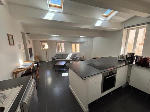 une cuisine avec un comptoir et un salon dans l'établissement Appartement cosy, idéalement situé près du port de Cassis, à Cassis