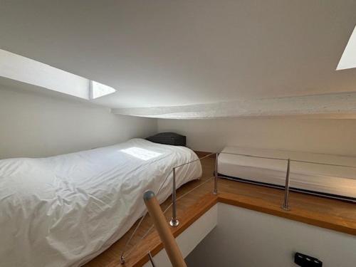 une petite pièce avec un lit et une fenêtre dans l'établissement Appartement cosy, idéalement situé près du port de Cassis, à Cassis