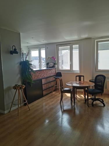 un salon avec une table et des chaises dans l'établissement Les coquelicots, à Romainville