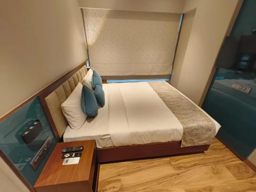 a small room with a bed and a table at Hotel Flexi Residency Mumbai International Airport in Mumbai