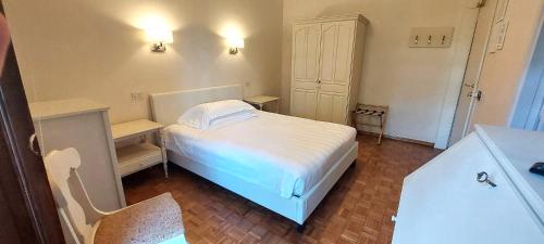 a small bedroom with a white bed and a desk at Hotel Villa Quiete in Montecassiano