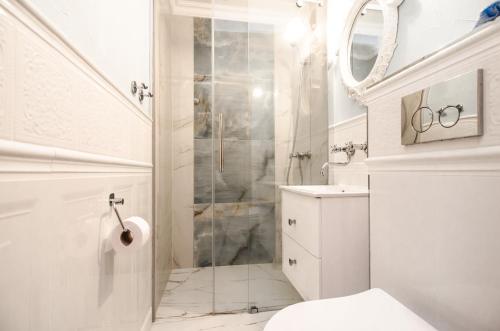 a white bathroom with a shower and a toilet at Willa Koron a Mielno in Mielno