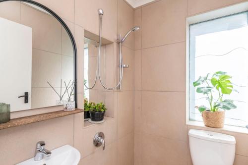 a bathroom with a shower and a toilet and a sink at Tranquil Flatlet in Seapoint in Cape Town