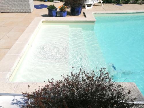 une piscine avec de l'eau bleue dans une cour dans l'établissement UN BALCON sur LA SAINTE VICTOIRE, à Cadolive