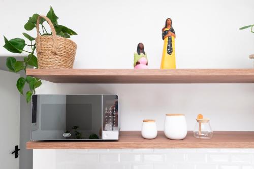 a shelf with a microwave on top of it at Tranquil Flatlet in Seapoint in Cape Town