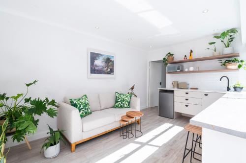 a living room with a couch and a kitchen at Tranquil Flatlet in Seapoint in Cape Town