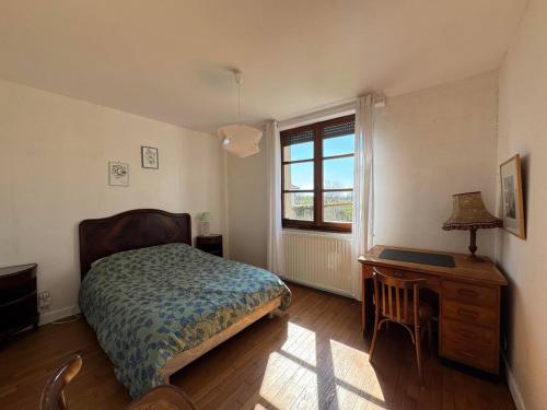 ein Schlafzimmer mit Bett, Schreibtisch und Fenster in der Unterkunft Le nid d'Hirondelle in Vanault-les-Dames