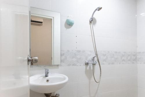 a bathroom with a sink and a shower at INNCA Mimpi Inn, Semarang in Jatingaleh