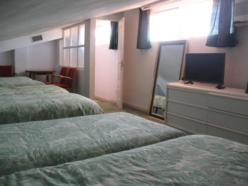a hotel room with two beds and a flat screen tv at Residencial Playa Lisa in Boadilla del Monte
