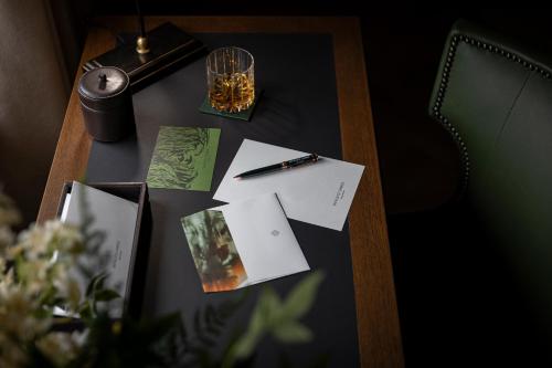 a table with papers and a pen on top of it at Dunluce Lodge - Small Luxury Hotels of the World in Portrush