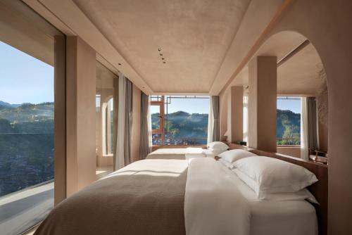 XijiangにあるSeven Letters Preface Hotelの大きな窓のあるベッドが2つある寝室