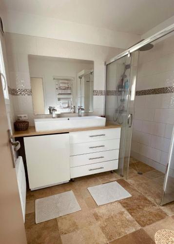 une salle de bain avec un lavabo blanc et une douche dans l'établissement Appartement centre ville, à Cogolin