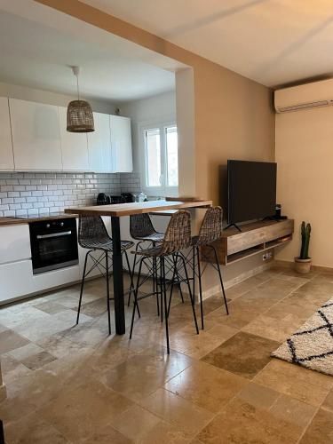 une cuisine avec une table et des chaises ainsi qu'une télévision dans l'établissement Appartement centre ville, à Cogolin
