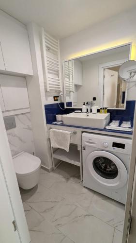 a bathroom with a washing machine and a sink at Orbi City, block C in Batumi