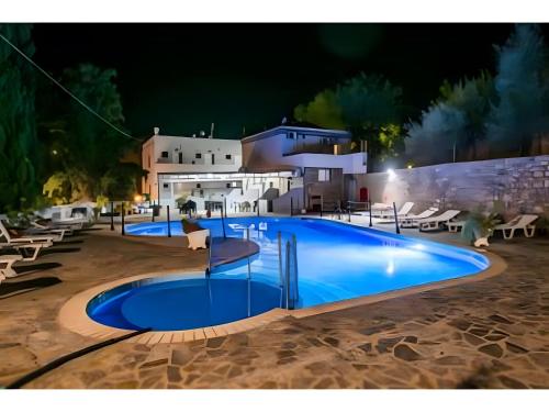 a swimming pool in front of a house at night at Ilias Studios Sevasti Kalymnos in Panormos Kalymnos