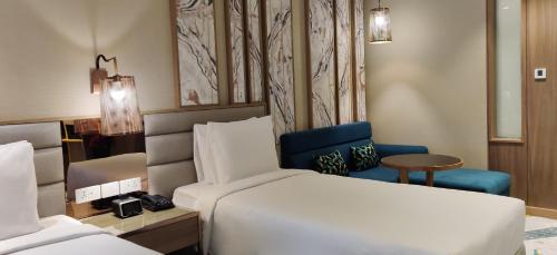 a hotel room with a bed and a chair at Holiday Inn Chandigarh Zirakpur by IHG in Chandīgarh