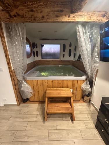 a tub in the middle of a room with a table at Sioło Bobolin II in Bobolin