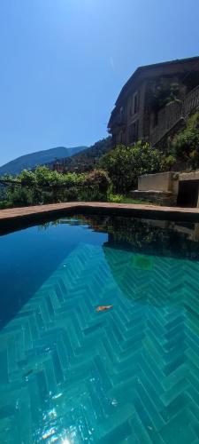 a large pool of blue water in front of a building at Casa Pablo in Badalucco