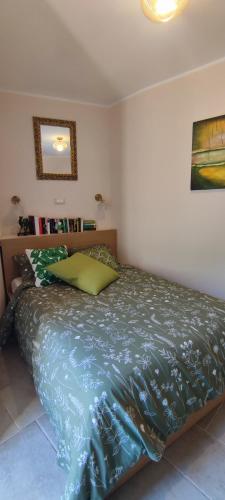 a bedroom with a bed with a green comforter at Casa Pablo in Badalucco