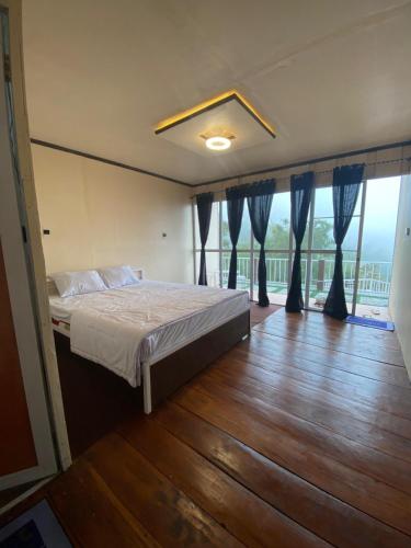 a bedroom with a bed and a large window at Cepogo Cabin Mangli Cabin Keluarga & Syariah in Prampelan