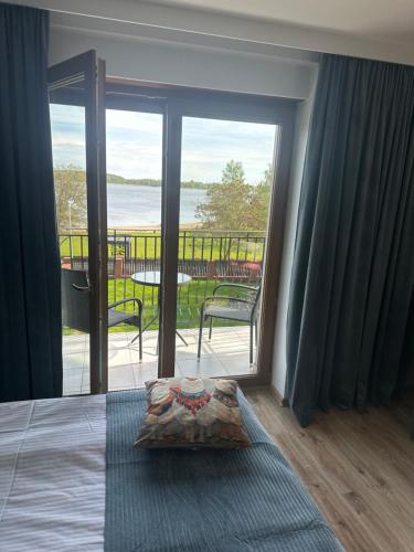 a bedroom with a bed and a view of a balcony at Świat Jezior in Mikołajki