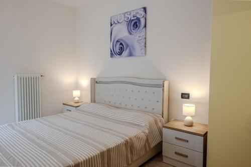 Un dormitorio pequeño con una cama y dos mesitas de noche. en Viotto Apartments, en Lido di Jesolo