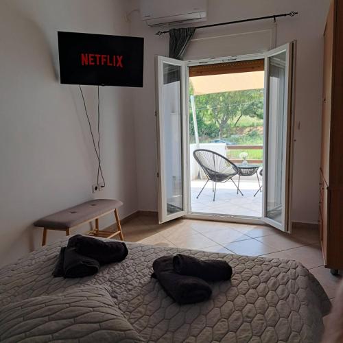 a bedroom with a bed and a sliding glass door at Eunoia Syros Suites in Ermoupoli