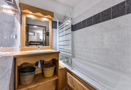 une salle de bain avec un lavabo, une baignoire et un miroir dans l'établissement Résidence Les Hauts De Preclaux - Appartement 6 personnes au coeur des Orres 1800 MAE-5351, aux Orres