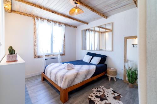 a bedroom with a bed in a room with windows at La Petite Parenthèse Jardin, Parking & Proche Gare in Trappes