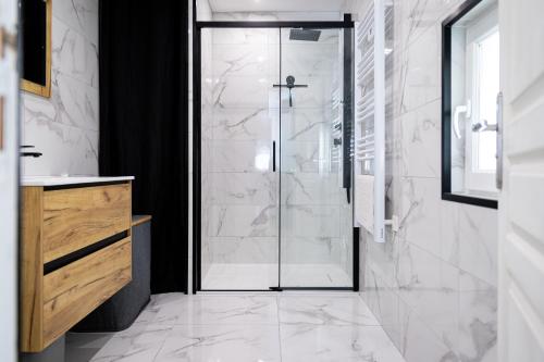 a shower with a glass door in a bathroom at La Petite Parenthèse Jardin, Parking & Proche Gare in Trappes