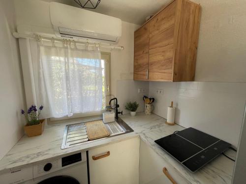 une petite cuisine avec un comptoir et une fenêtre dans l'établissement MAS Chalet 6 7persClimPiscineJardin, au Barcarès