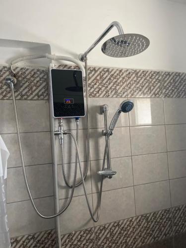 una doccia con un cellulare in un bagno di The Coffee Residences- 3 Bedroom Apartments-4km to JKIA, 7km to CBD a Nairobi