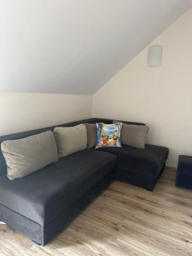 a black couch sitting in a living room at Świat Jezior in Mikołajki