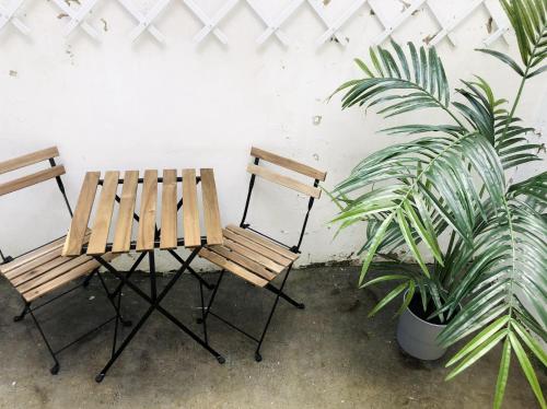 two wooden chairs and a table and a potted plant at Florimond cosy apparts in Saint-Quentin