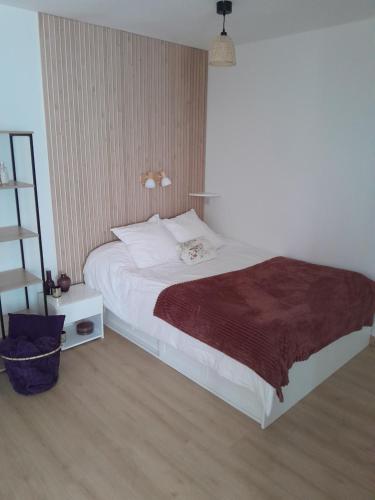 a bedroom with a white bed with a red blanket at L'A n n e x e de Vic Le Comte in Vic-le-Comte