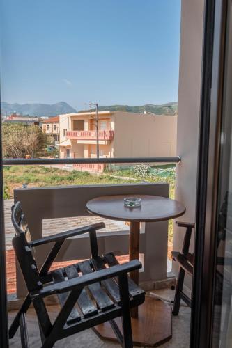 a table and a chair on a balcony with a view at Argo Rooms-Papadakis in Kissamos