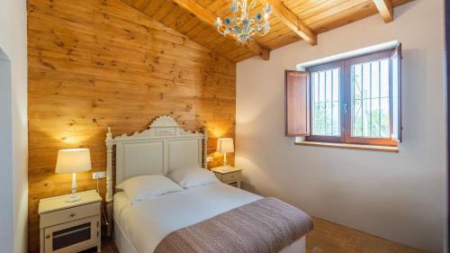 a bedroom with a white bed and a wooden wall at Casa La Estrella Azul Vélez-Málaga by Ruralidays in Vélez-Málaga