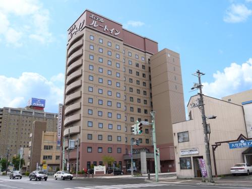 a tall building on the corner of a city street at Hotel Route-Inn Asahikawa Ekimae Ichijodori in Asahikawa