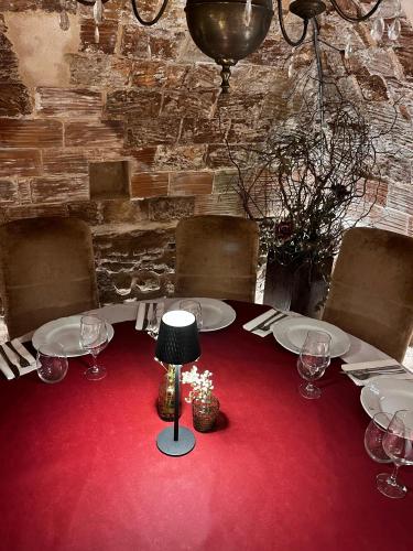 a table with white plates and a lamp on a red carpet at La Casa de los Coy in Mula