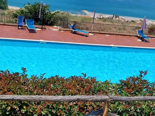 una piscina con sedie e l'oceano sullo sfondo di Casa Bonifati a Cittadella del Capo