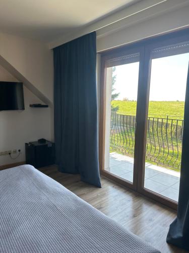 a bedroom with a sliding glass door to a balcony at Świat Jezior in Mikołajki