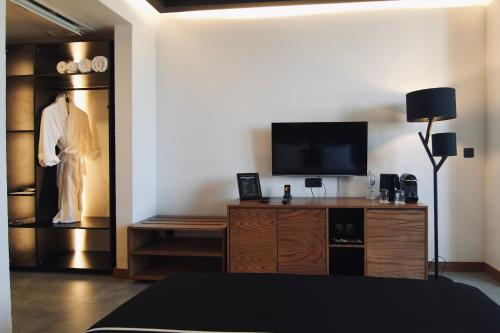 a bedroom with a dresser and a tv in a room at The Local House Alaçatı in Alacati
