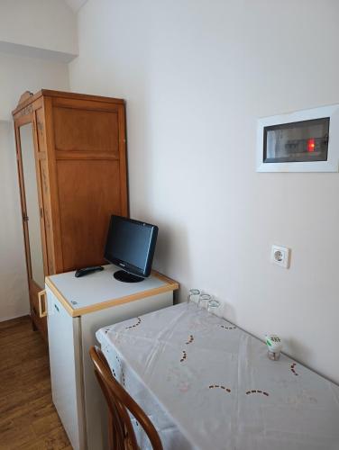 a room with a table with a laptop on top of a refrigerator at Anesis Hotel in Loutra Edipsou