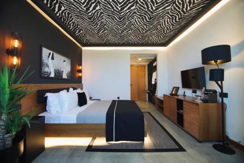 a hotel room with a bed and a flat screen tv at The Local House Alaçatı in Alacati