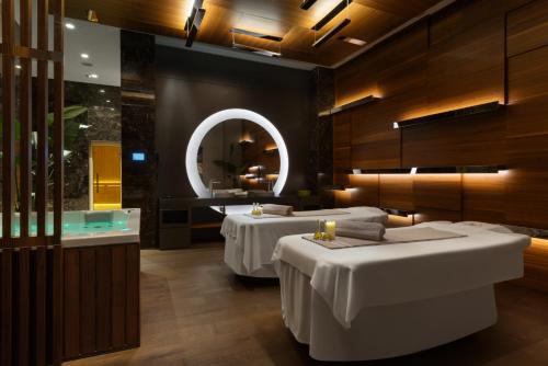 two beds in a room with a tub and a mirror at Wyndham Grand Istanbul Levent Hotel & Conference Center in Istanbul