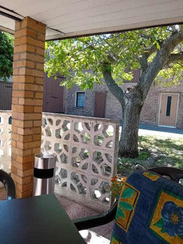 a patio with a table and a fence and a tree at Großes Haus in Zossen