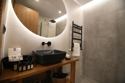 a bathroom with a black sink and a mirror at The Local House Alaçatı in Alacati
