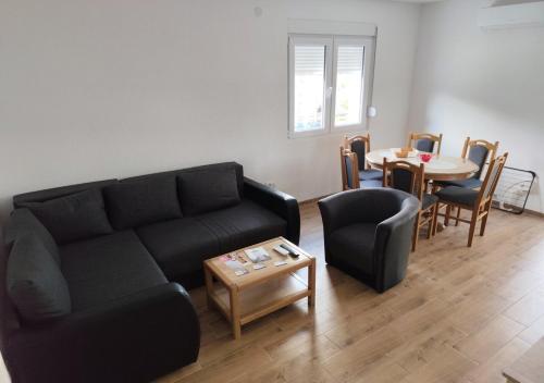 a living room with a black couch and a table at Suncani Breg in Soko Banja