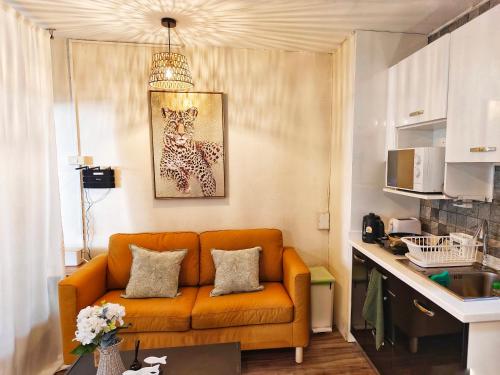 a living room with an orange couch in a kitchen at Peaceful Condo at Happening Nimman in Chiang Mai