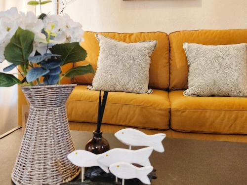 a living room with a couch and a vase with flowers at Peaceful Condo at Happening Nimman in Chiang Mai